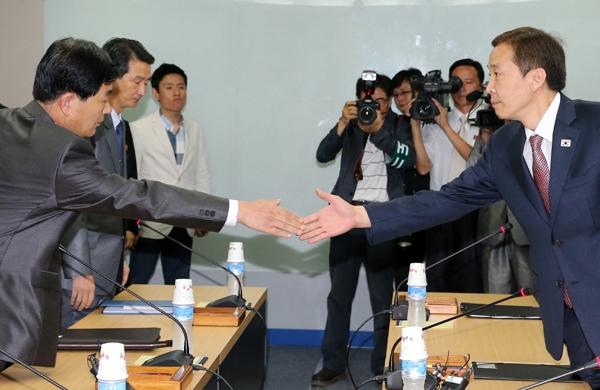 Chefe da delegação norte-coreana Pak Chol-Su (E) cumprimenta o sul-coreano Kim Ki-Woong (D) (France Press)