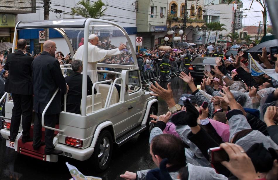 O papa Francisco acena para a multidão nas ruas de Aparecida (France Press)