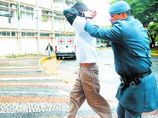 Policial Militar conduz um dos traficantes presos para prestar depoimento  (Érica Dezonne/AAN)