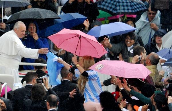 Papa acena para multidão que enfrentou a chuva na Praça São Pedro, no Vaticano (France Press)