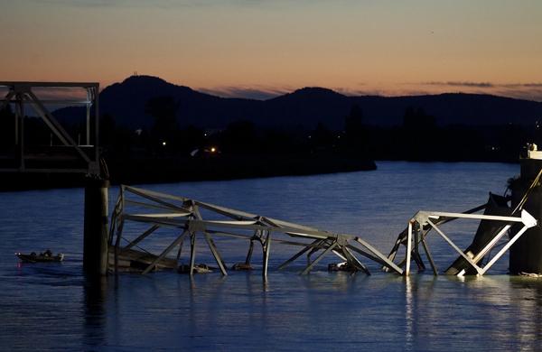 Barco (E) resgata passageiros e motoristas que estavam na ponte no momento do acidente (France Press)