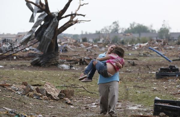 Mulher carrega vítima de tornado nos braços em Oklahoma City, nos Estados Unidos (France Press)