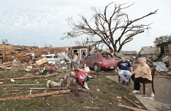Família conversa em frente à casa destruída por passagem de tornado em Oklahoma (France Press)