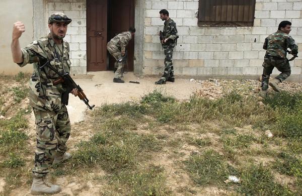 Soldados sírios durante invasão a Homs neste domingo (France Press)