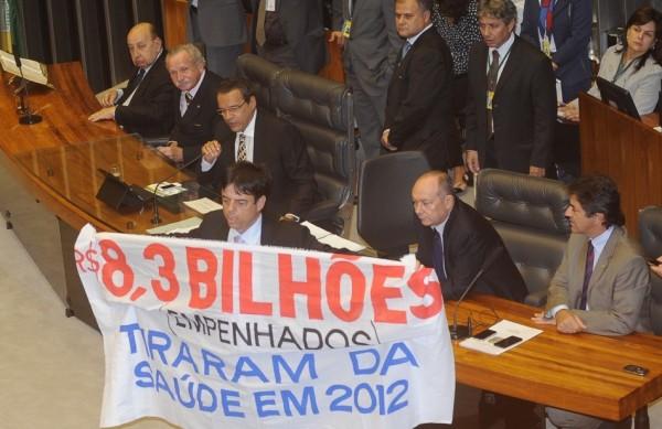 Deputado Toninho Pinheiro (PP-MG) subiu à Mesa da Casa e exibiu uma faixa cobrando a liberação de emendas para a saúde durante a sessão (Agência Brasil)
