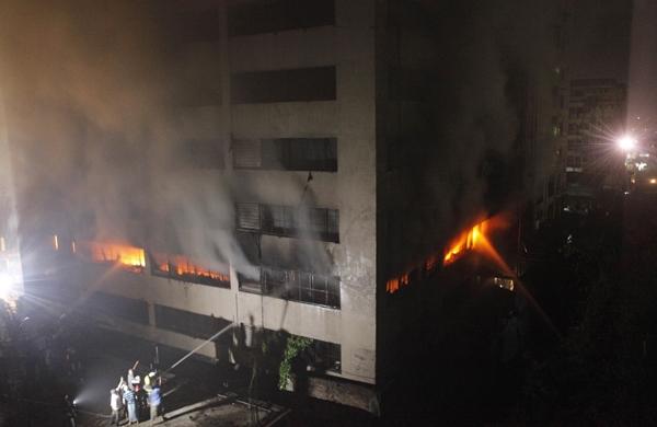 Bombeiros e voluntários tentam controlar as chamas em um edifício de Bangladesh (France Press)